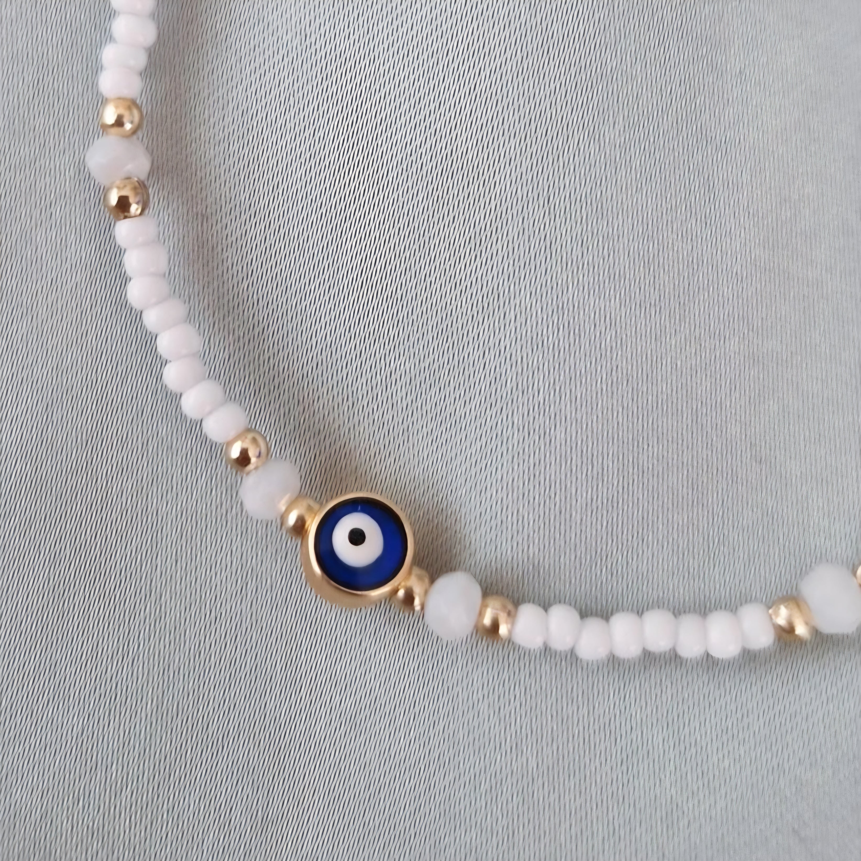 Bracelet fantaisie perles blanches et dorées œil